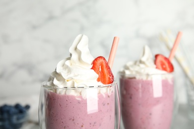 Photo of Tasty milk shake with strawberry in glass, closeup
