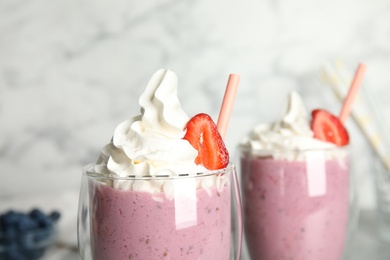 Tasty milk shake with strawberry in glass, closeup