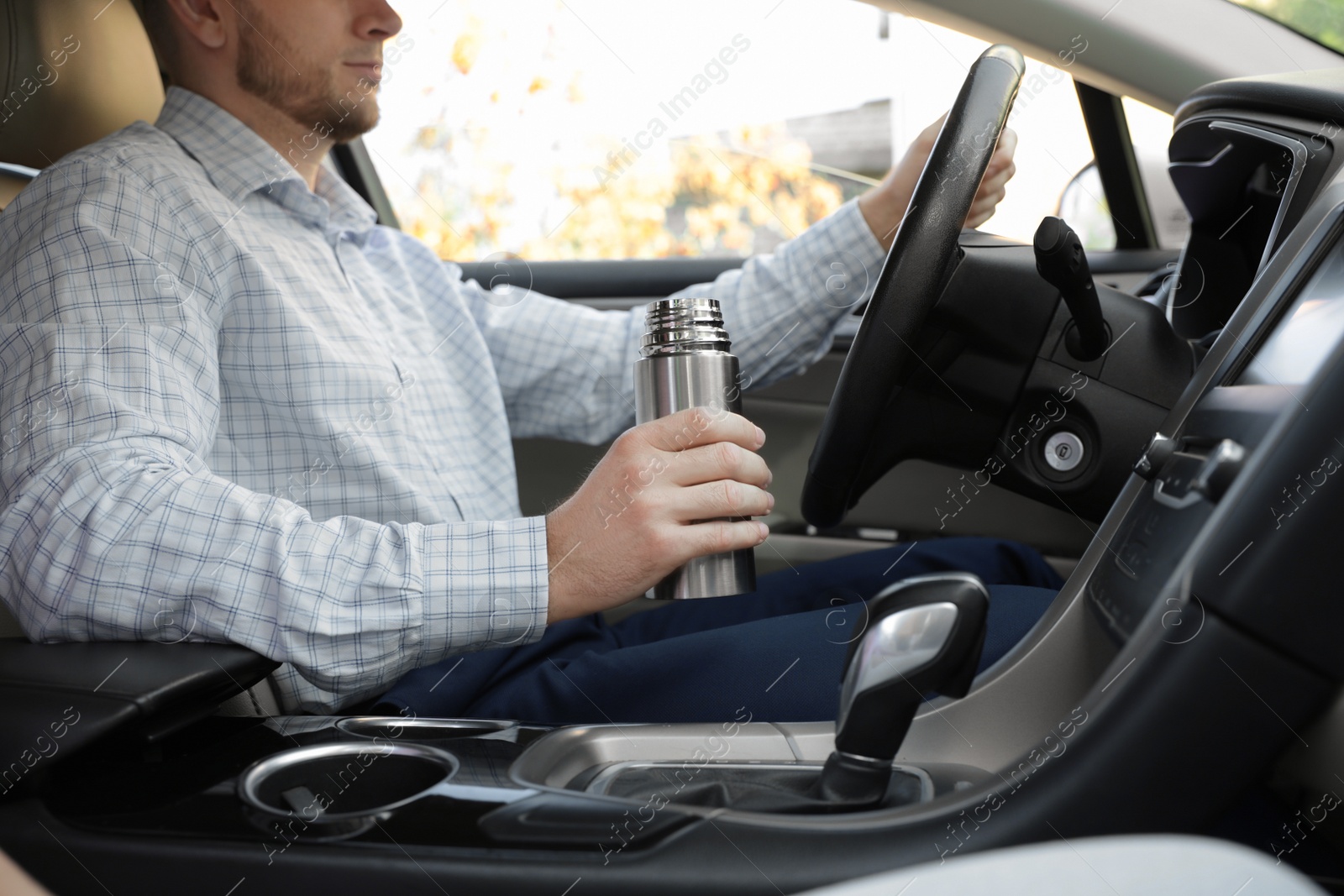 Photo of Man with thermos driving car, closeup view