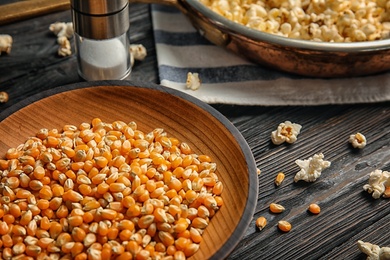 Photo of Plate with corn kernels on wooden table, closeup