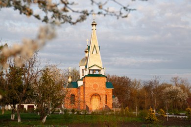 Beautiful view of village church and green lawn on spring day
