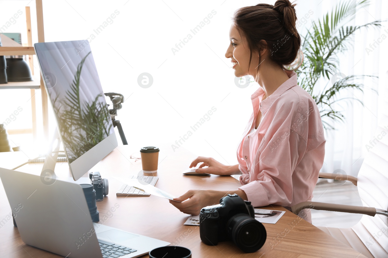 Photo of Professional photographer working at table in office