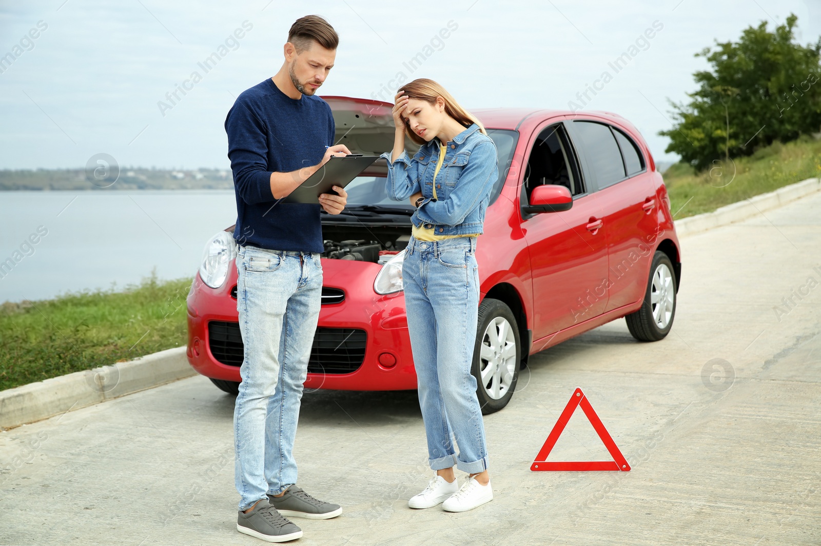 Photo of People near broken car on country road