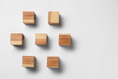 Blank wooden cubes on white background, flat lay. Space for text