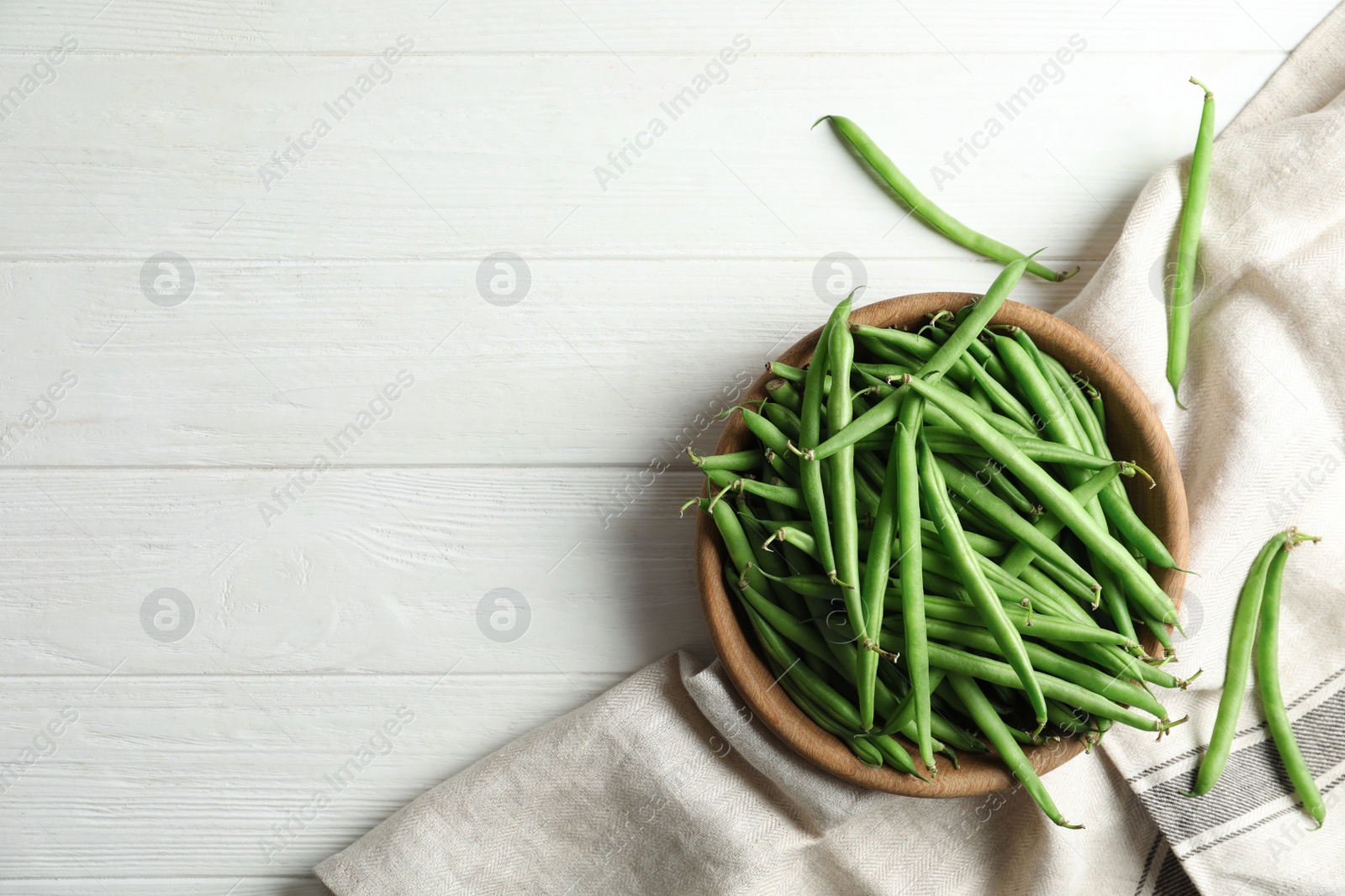 Photo of Fresh green beans on white wooden table, flat lay. Space for text