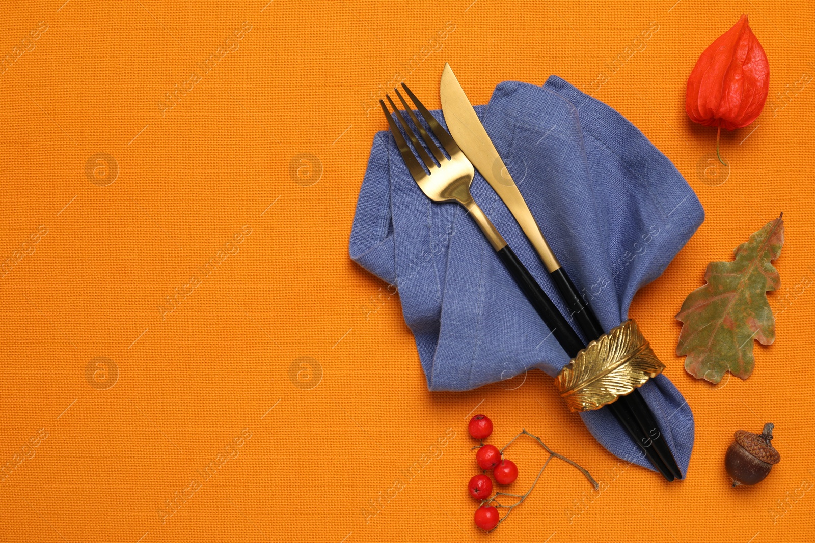 Flat lay composition with cutlery and napkin on orange tablecloth, space for text. Table setting Photo of Flat lay composition with cutlery and napkin on orange tablecloth, space for text. Table setting