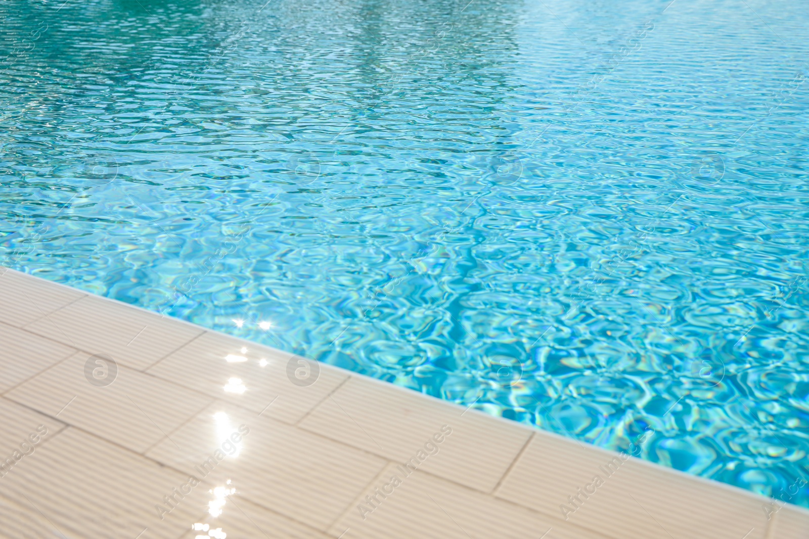 Photo of Outdoor swimming pool with clear water on sunny day. Summer vacation