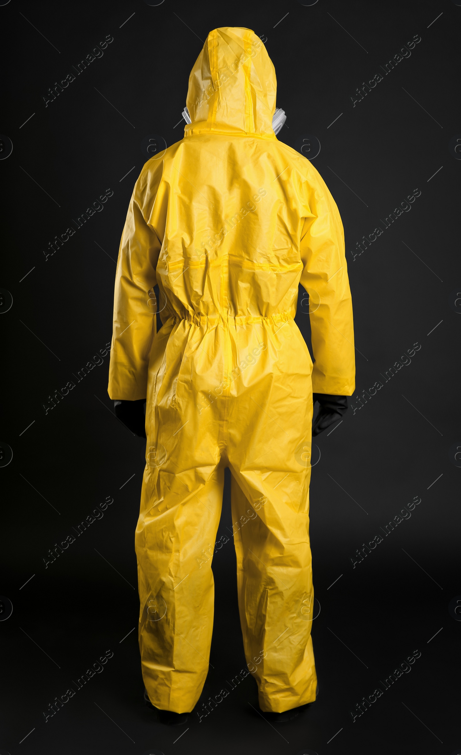 Photo of Man wearing chemical protective suit on black background, back view. Virus research