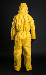 Man wearing chemical protective suit on black background, back view. Virus research