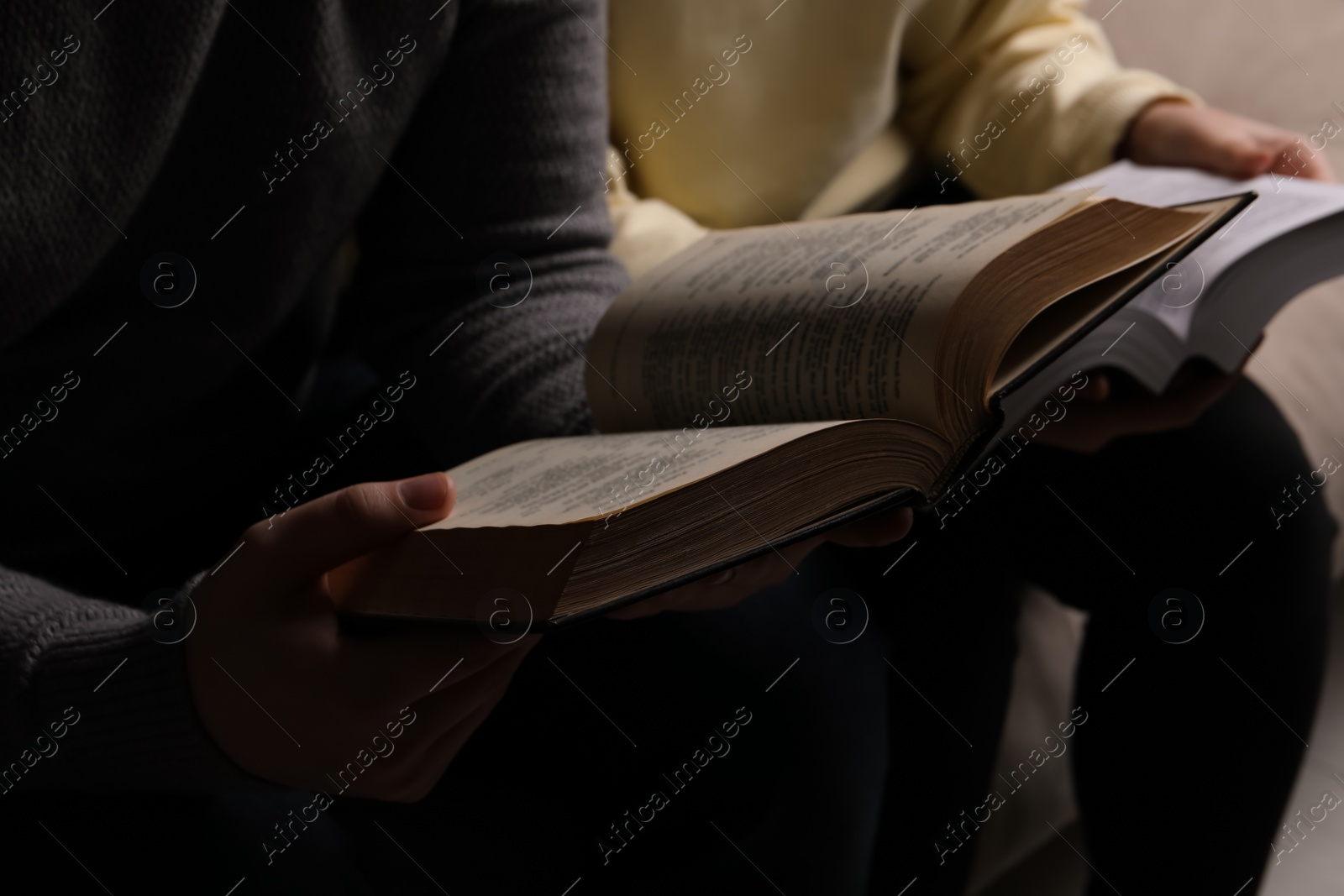 Photo of Couple sitting and reading holy Bibles, closeup