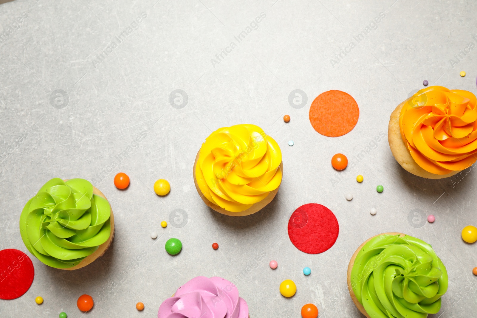 Photo of Colorful birthday cupcakes on light grey table, flat lay. Space for text