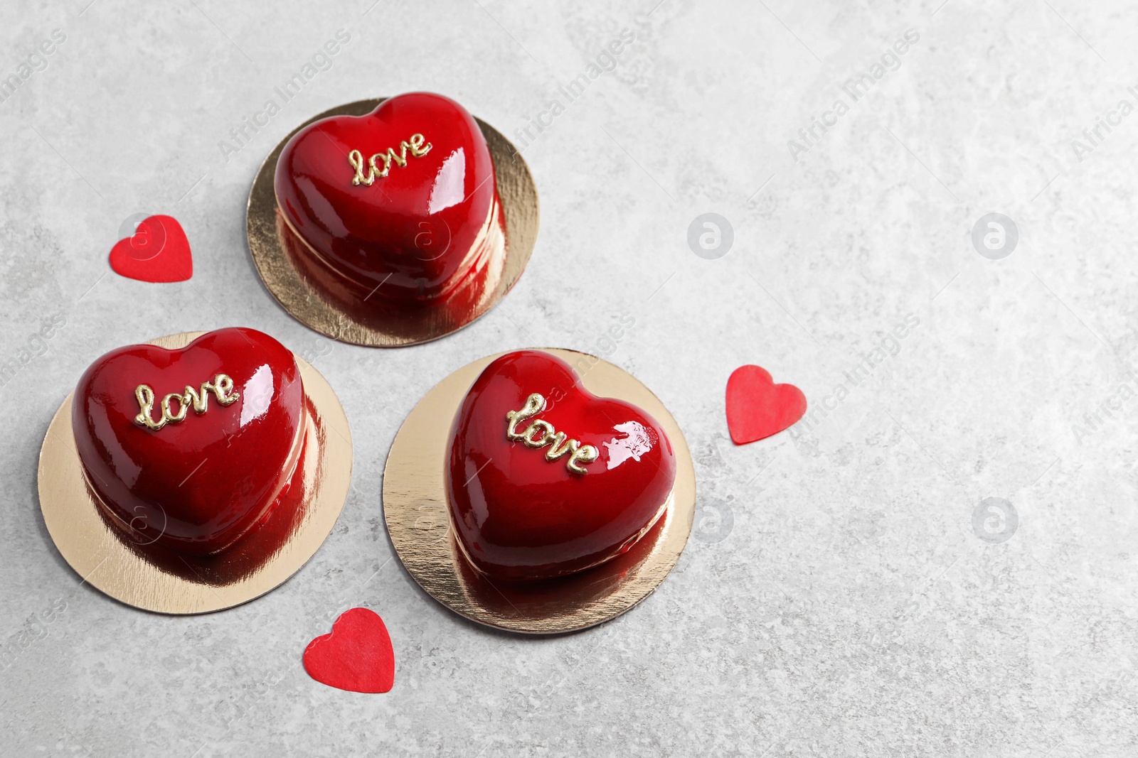 Photo of St. Valentine's Day. Delicious heart shaped cakes on light table, above view. Space for text