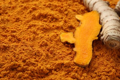 Photo of Raw roots on aromatic turmeric powder, closeup. Space for text