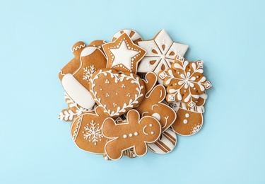 Photo of Pile of Christmas gingerbread cookies on light blue background, flat lay