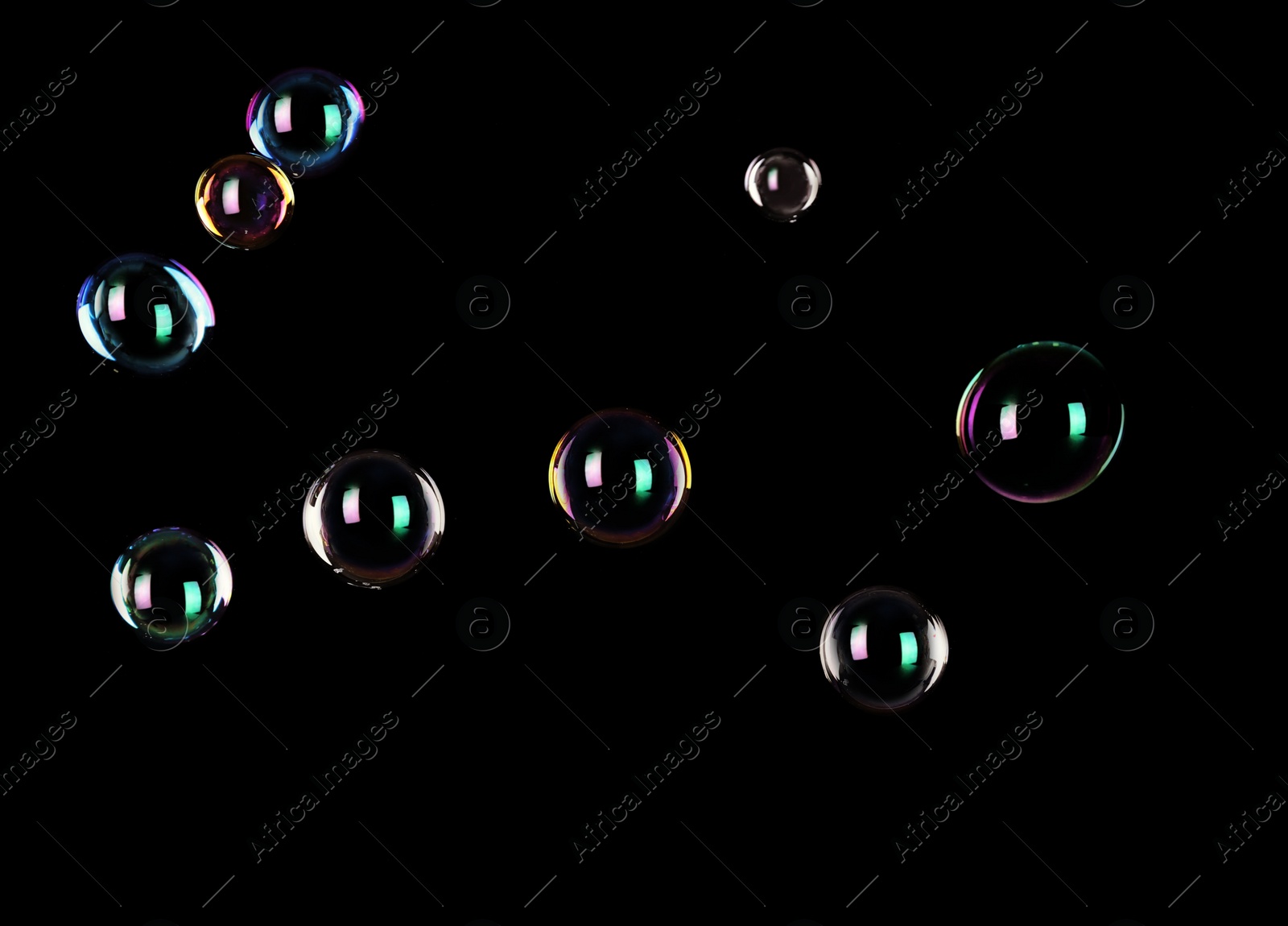 Photo of Beautiful translucent soap bubbles on dark background