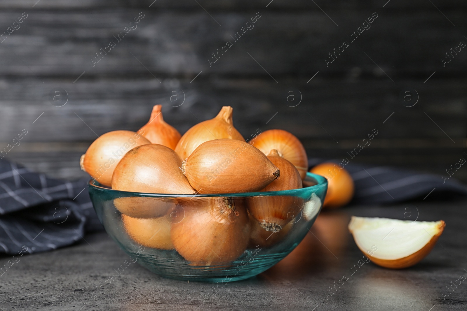 Photo of Bowl with fresh ripe onions on table