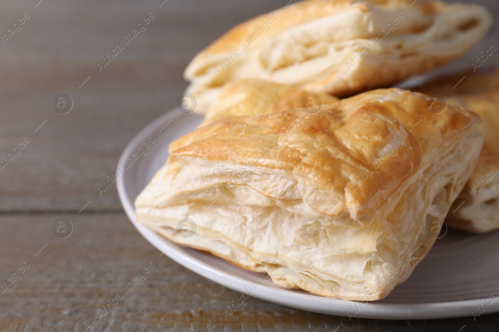 Photo of Delicious fresh puff pastries on wooden table, closeup