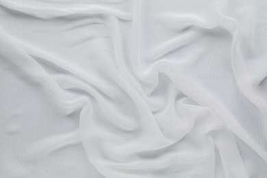 Beautiful white tulle fabric as background, top view