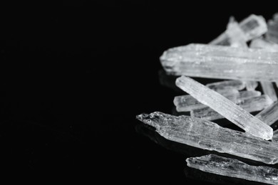Photo of Menthol crystals on black background, closeup. Space for text