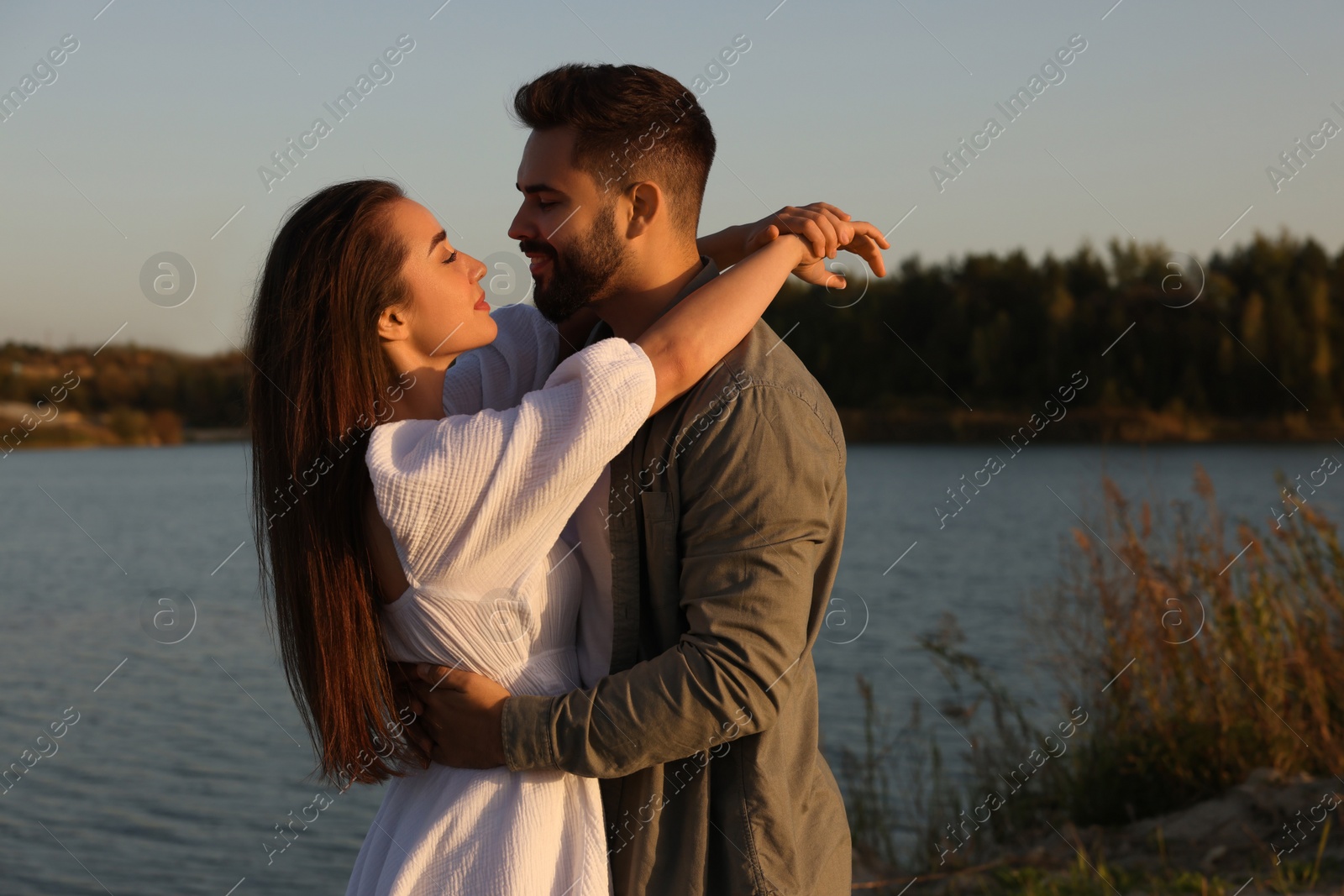 Photo of Beautiful couple dancing near river at sunset