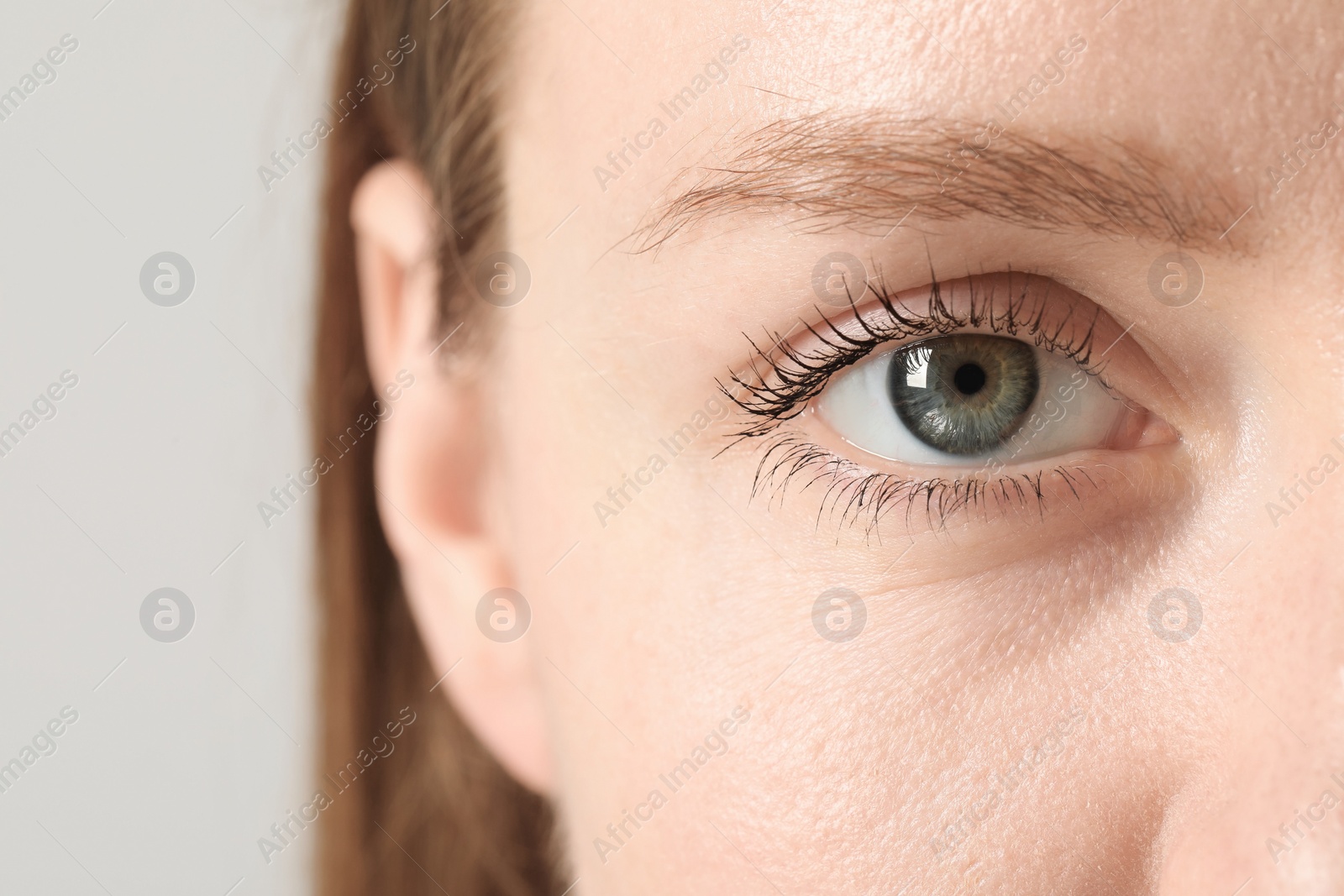 Photo of Closeup photo of woman with beautiful eyes on light background