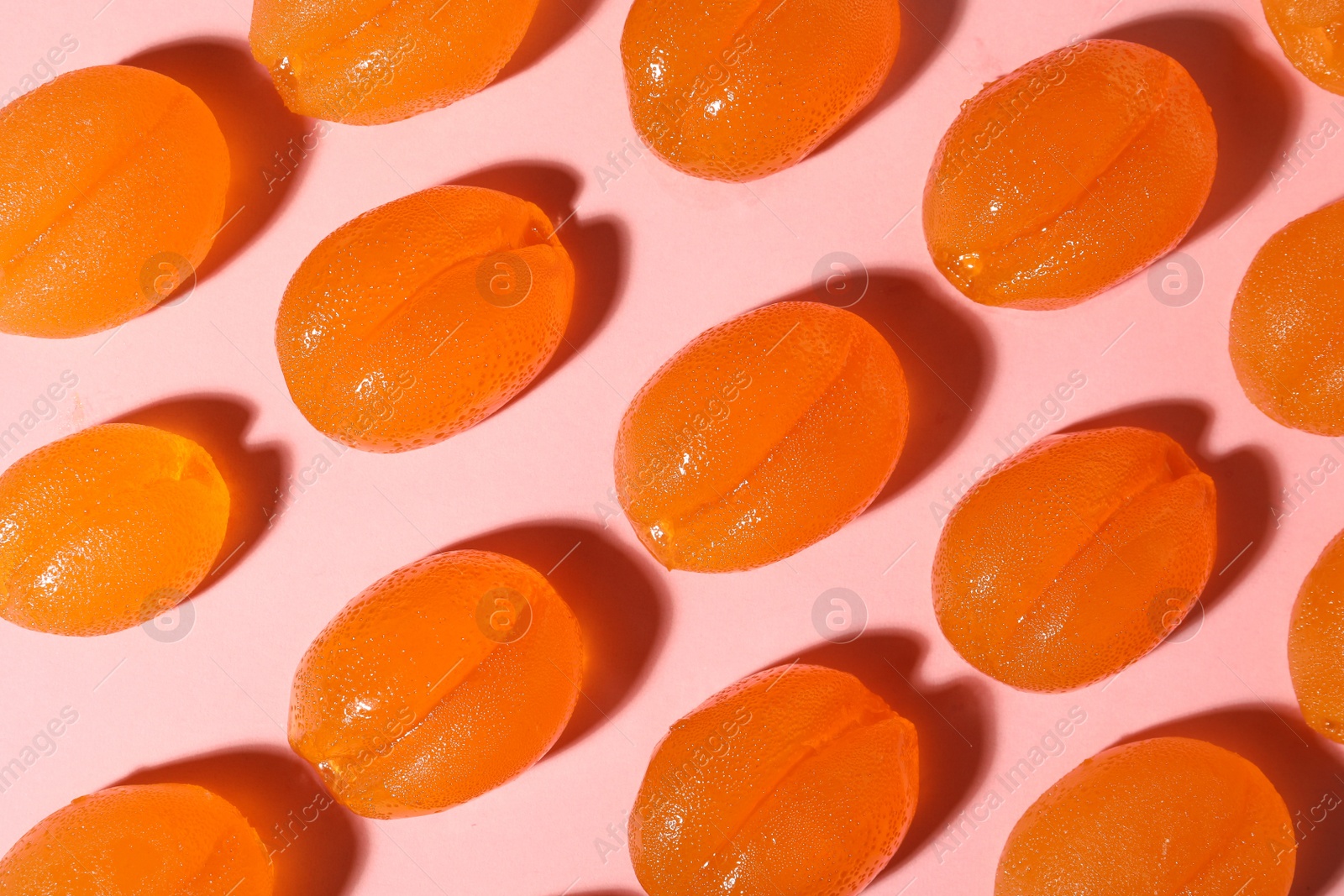 Photo of Delicious gummy candies on pink background, flat lay