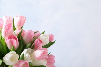 Photo of Beautiful bouquet of tulips against light background. Space for text