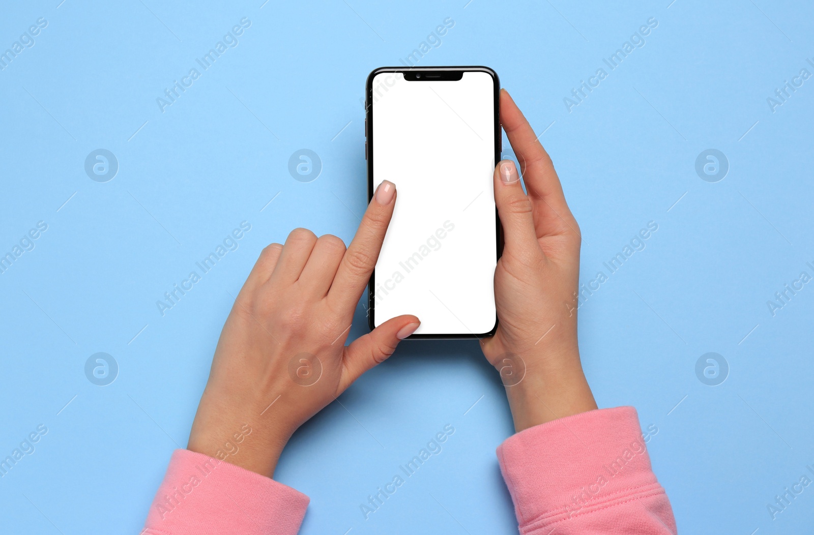 Photo of Woman using smartphone on light blue background, top view