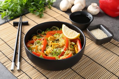 Photo of Stir-fry. Delicious cooked noodles with chicken and vegetables in bowl served on table