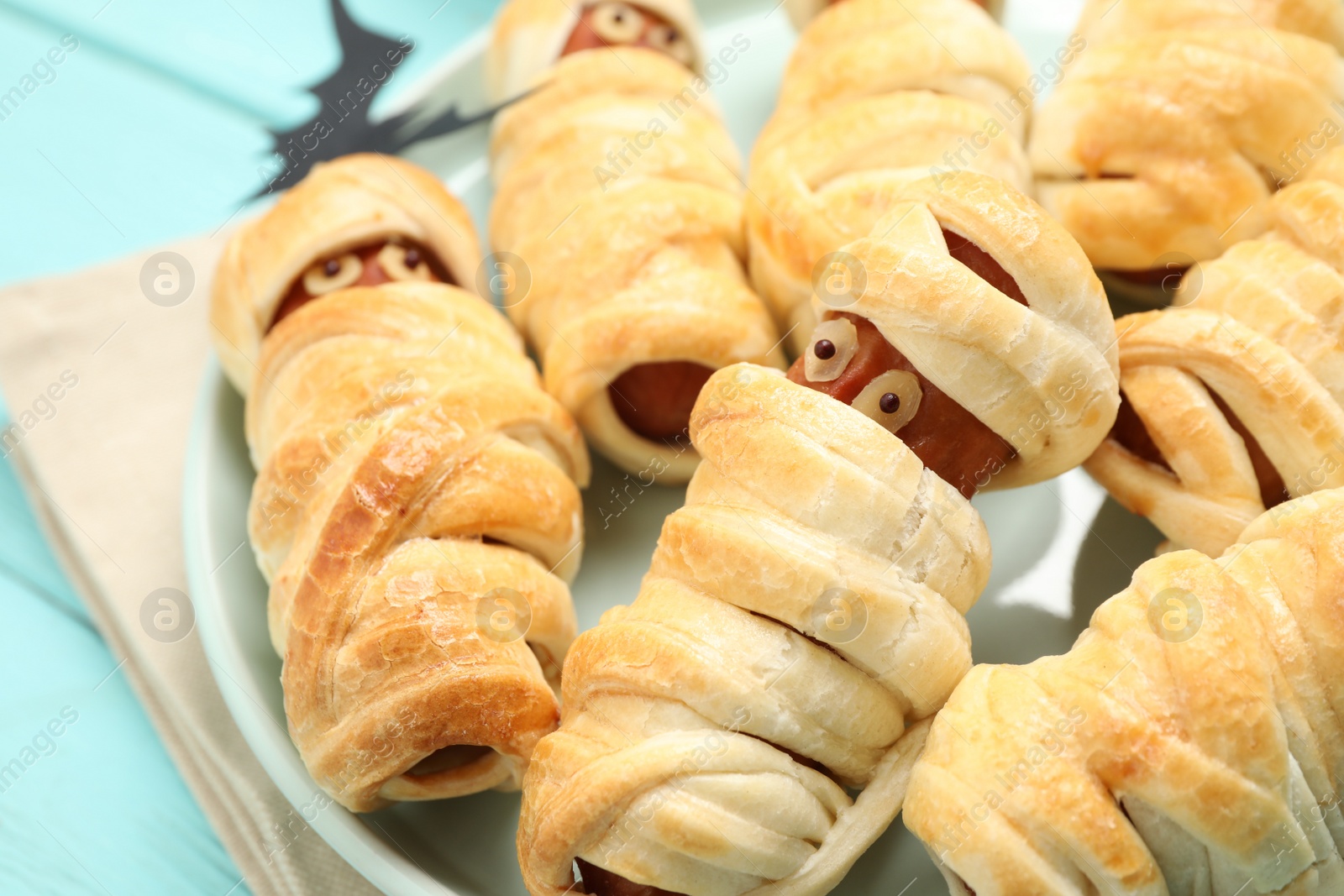 Photo of Spooky sausage mummies on table, closeup. Halloween treat