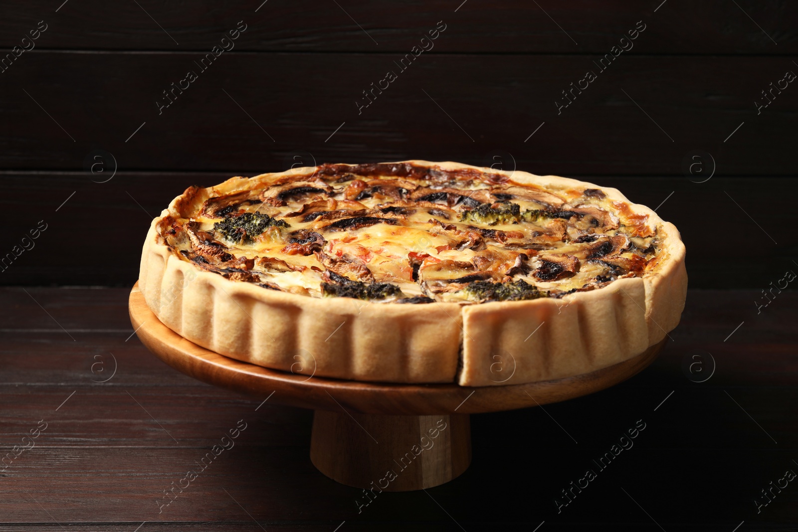 Photo of Delicious quiche with mushrooms on wooden table, closeup