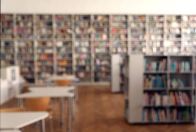 Photo of Blurred view of library interior with bookcases and tables