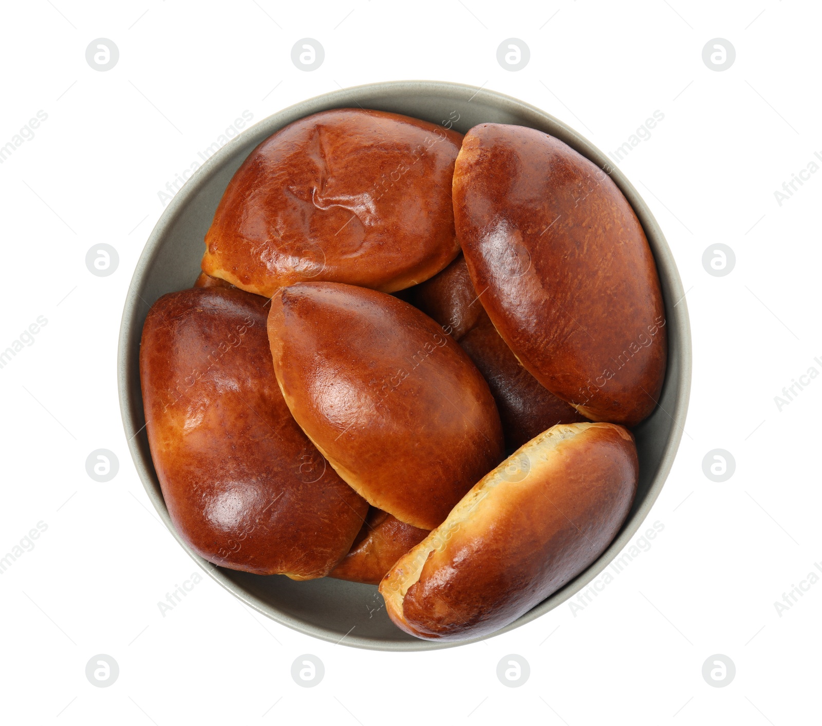 Photo of Bowl with delicious baked pirozhki on white background, top view