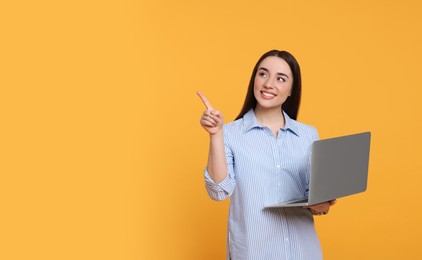 Photo of Smiling young woman with laptop on yellow background, space for text