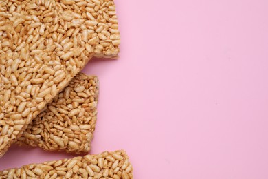 Photo of Puffed rice bars (kozinaki) on pink background, flat lay. Space for text