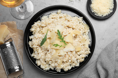 Delicious risotto with cheese on grey table, flat lay