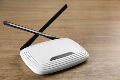 New modern Wi-Fi router on wooden background