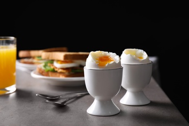 Photo of Soft boiled eggs served on grey table. Space for text