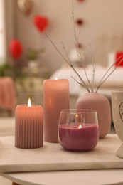 Photo of Burning candles on table in room. Interior design