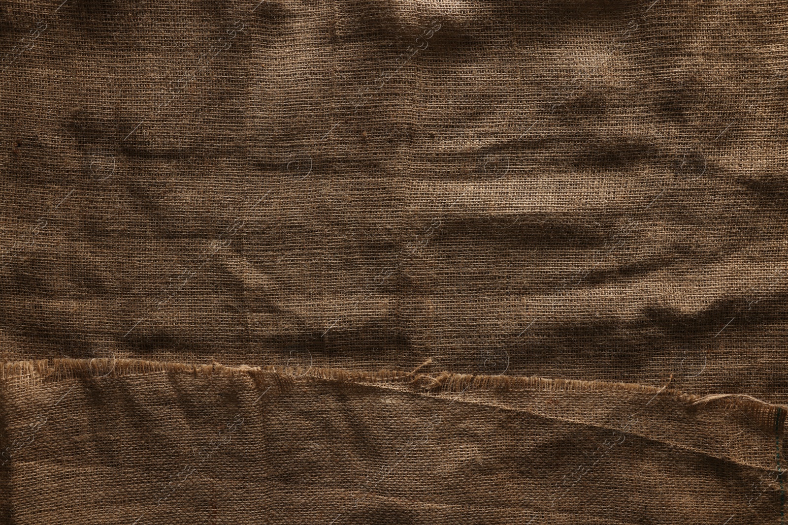 Photo of Texture of natural burlap fabric as background, top view