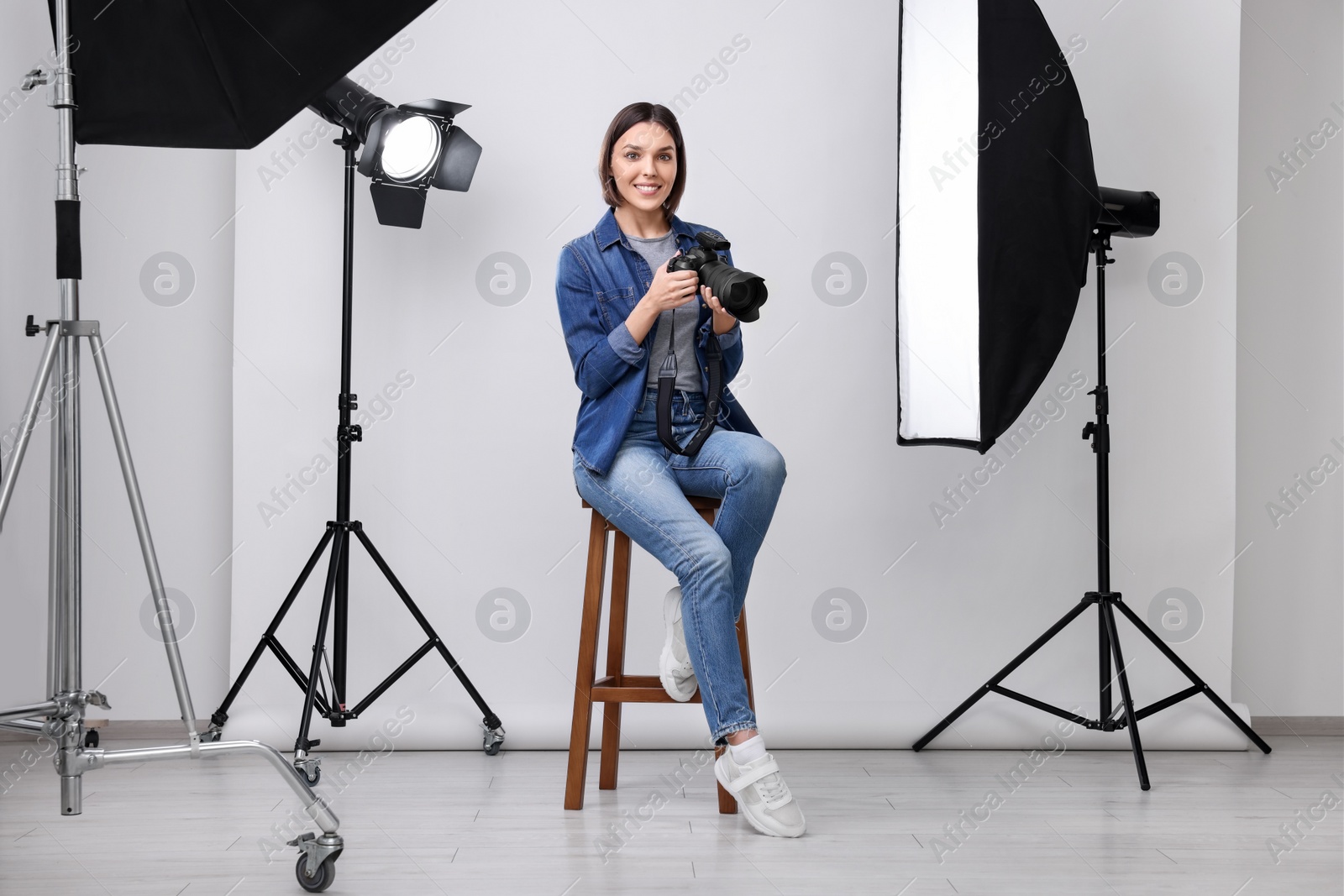 Photo of Professional photographer with camera in modern photo studio