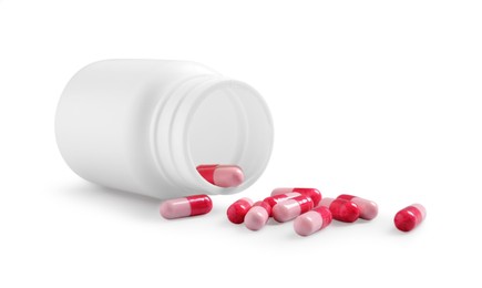 Medical bottle and pink pills on white background