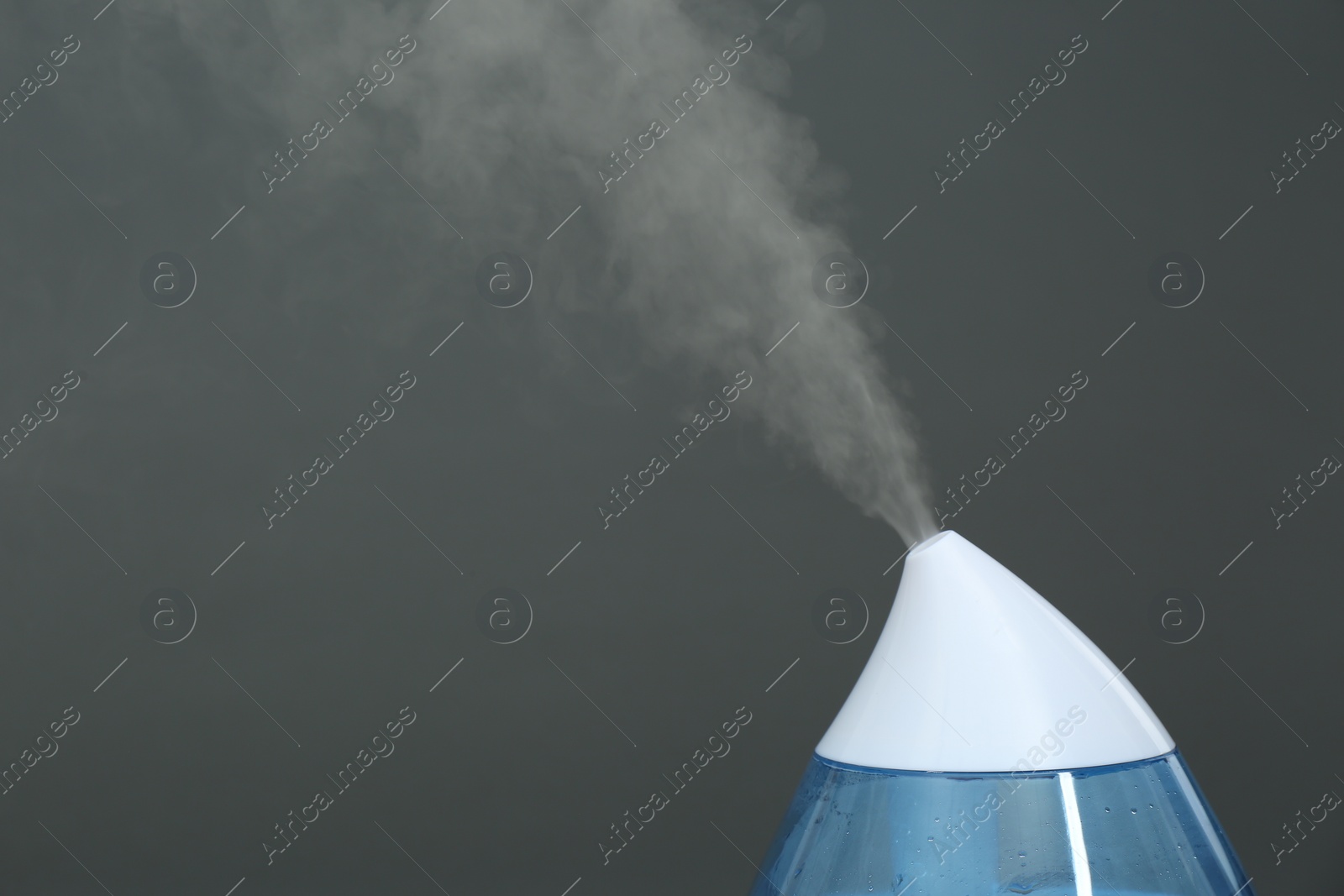 Photo of Modern air humidifier on grey background, closeup. Space for text