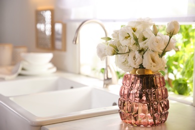 Photo of Bouquet of beautiful flowers on countertop in kitchen, space for text. Interior design