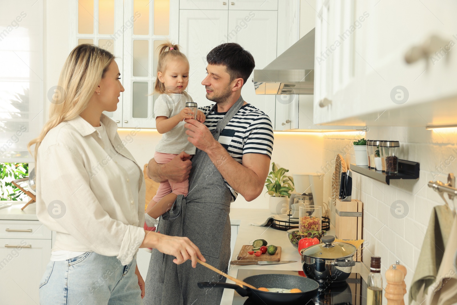 Photo of Happy lovely family cooking together in kitchen