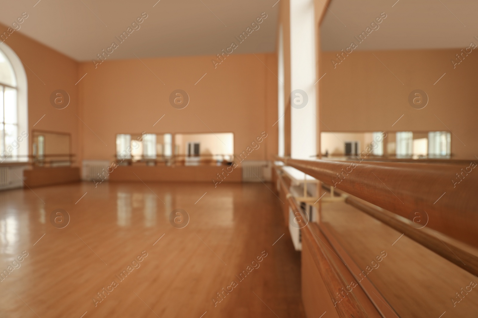 Photo of View of empty studio, focus on ballet barre. Space for text