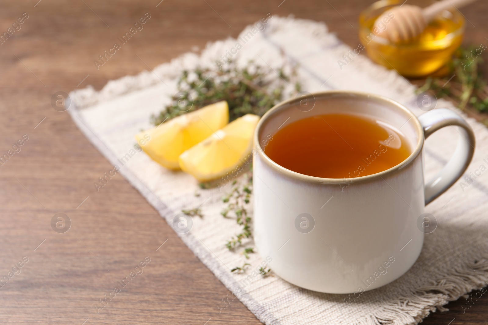 Photo of Aromatic herbal tea with thyme on wooden table, space for text