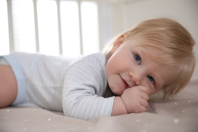 Photo of Adorable little baby lying in comfortable crib