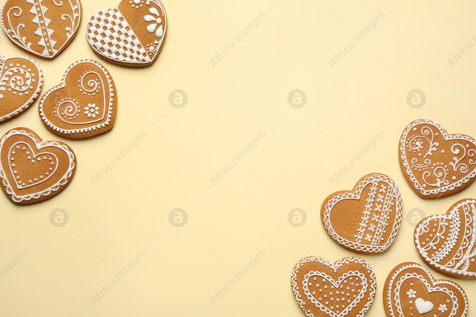 Photo of Tasty heart shaped gingerbread cookies on yellow background, flat lay. Space for text