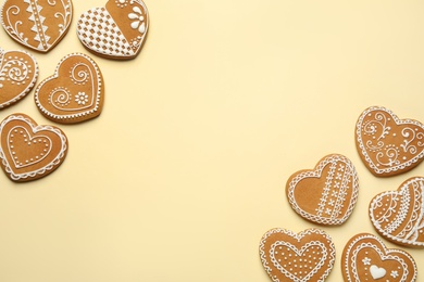 Photo of Tasty heart shaped gingerbread cookies on yellow background, flat lay. Space for text